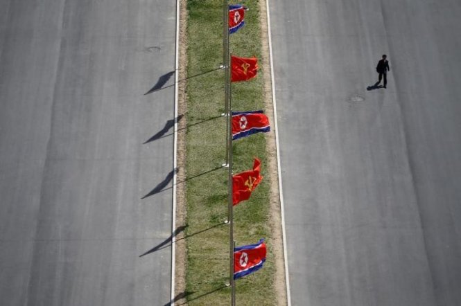 Một người đi trên con phố được trang hoàng những lá quốc kỳ trong dịp Triều Tiên kỷ niệm 105 năm ngày sinh của cố lãnh tụ Kim Nhật Thành vừa qua - Ảnh: Reuters